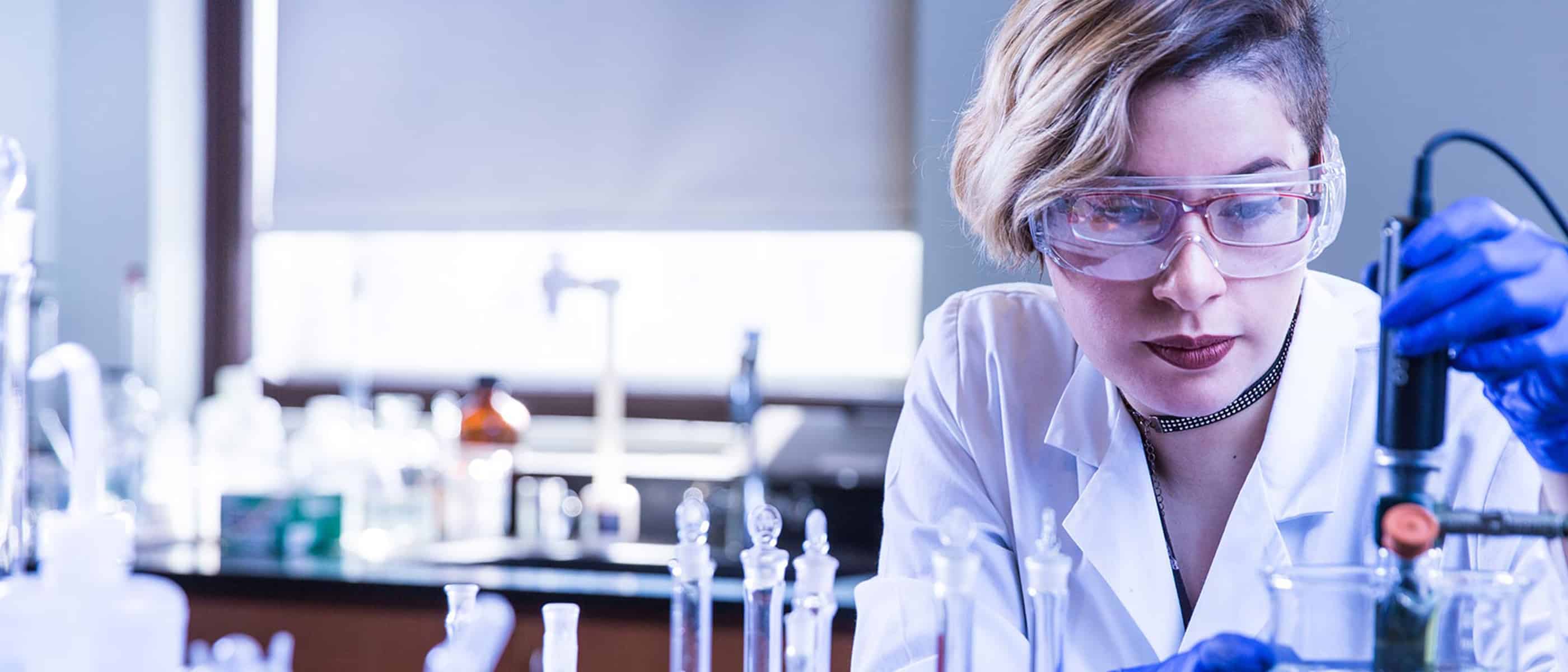 student in a science lab working with beakers