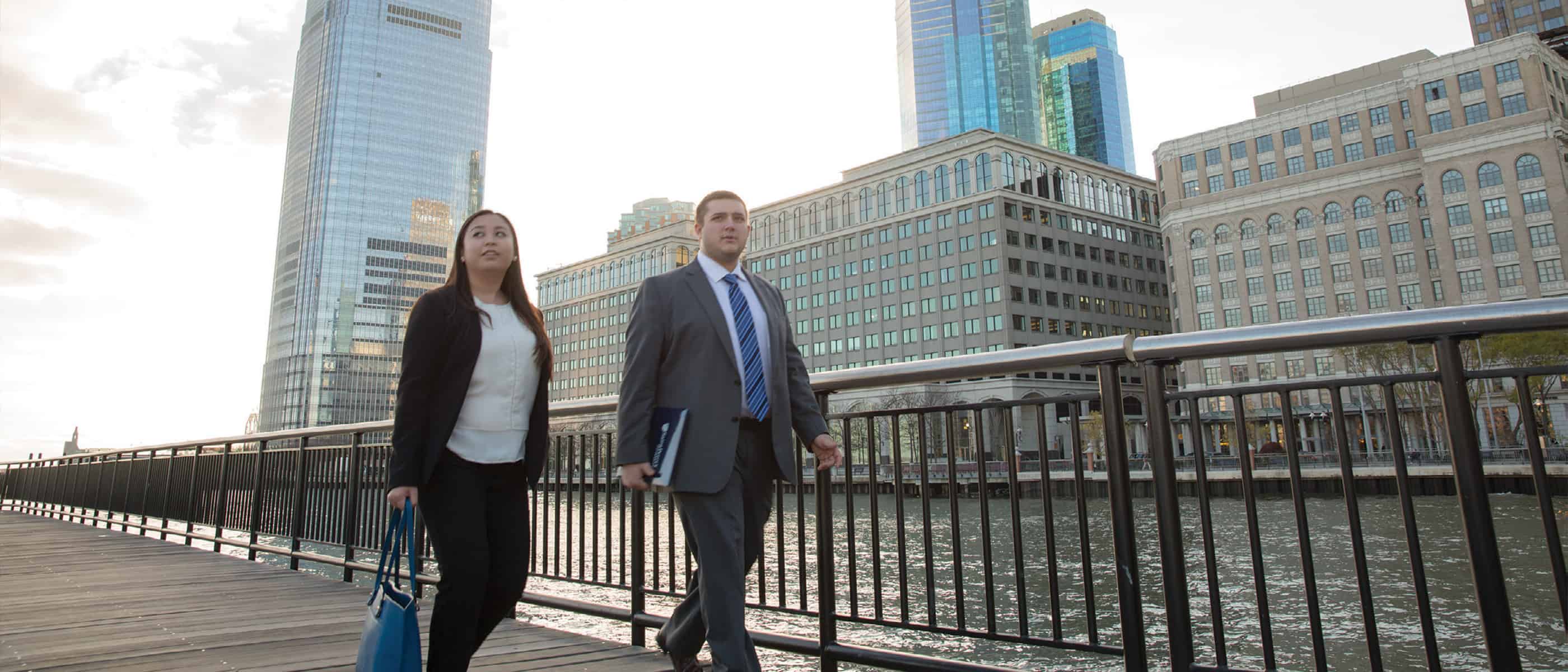 man and woman walking along the Jersey City waterfront