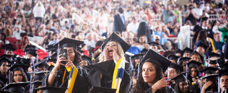 students wearing caps and gowns celebrating at commencement