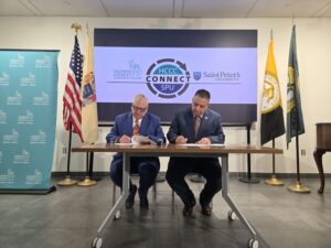 photo of Hubert Benitez, D.D.S., Ph.D., president of Saint Peter’s University, and Chris Reber, Ph.D., president of Hudson County Community College, signing the agreement