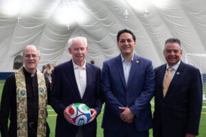photo of Fr. Jim Miracky, President Hubert Benitez, Tom Mac Mahon, and Councilman Zuppa at the Yanitelli Bubble opening