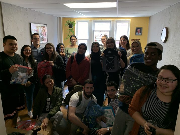 Students from the Muslim Students Association and Dr. Gerlach's HS-123 course pose with their finished book bags.