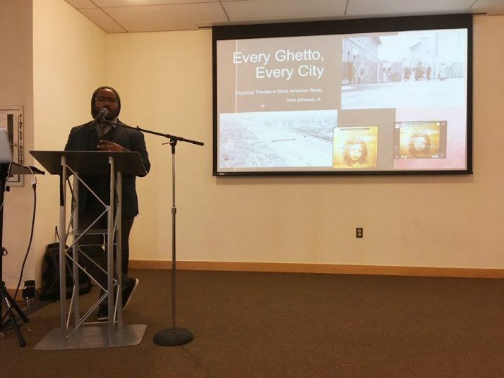 Dr. John Johnson, Jr. at the podium presenting his paper entitled "Every Ghetto, Every City."