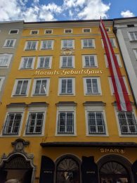 A bright yellow building with the words "Mozart's Geburtshaus" translating to "birthing center of Mozart." This is the birthplace of composer Wolfgang Amadeus Mozart in Salzburg, Austria.