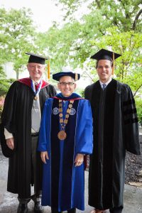 male graduates surrounding Eugene J. Cornacchia